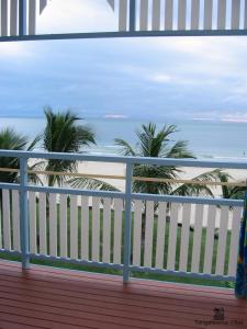 a balcony with a view of the beach and palm trees at Villa 20 in Tangalooma