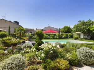 a garden with a swimming pool and plants at Charmante villa au cœur d'Eygalières avec piscine chauffée - FR-1-599-19 in Eygalières