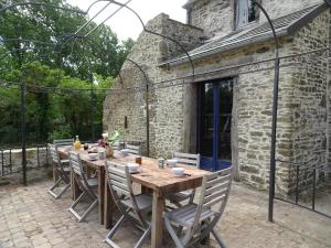 a wooden table and chairs on a patio at Manor in Cotentin with Historic Charm in Saint-Lo-dʼOurville
