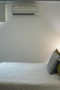 a white bed with two pillows on top of it at ARMONIA 408 APARTMENT IN GAZCUE in Santo Domingo
