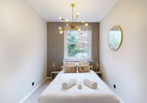a bedroom with a bed with two towels on it at Modern 2 bedroom flat in Hampstead Heath in London