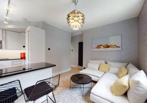 a living room with a white couch and a kitchen at Modern 2 bedroom flat in Hampstead Heath in London