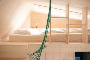 a hammock is hanging in a room with a bed at Tiny House Pioneer 18 Zur Meerseite - Green Tiny Village Harlesiel in Carolinensiel