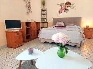 um quarto com uma cama com um vaso de flores sobre uma mesa em Holiday home near the sea, Audierne em Audierne