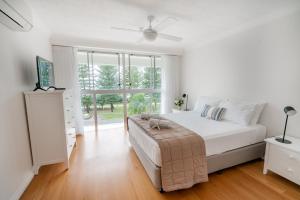 a living room with a bed and a tv at Cashelmara Beachfront Apartments in Gold Coast