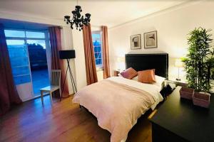 a bedroom with a bed and a large window at Luxury 3 bedroom 3 and a half bathroom flat in Swiss Cottage in London