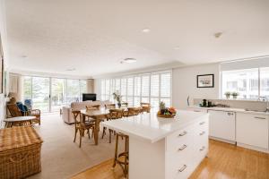 a kitchen with a table, chairs and a refrigerator at Cashelmara Beachfront Apartments in Gold Coast