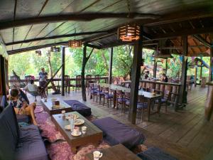 a restaurant with tables and chairs and people sitting at tables at Nature Lodge in Sen Monorom