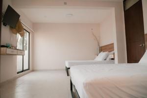 a bedroom with two beds and a window at Hotel Fratelli in Aguascalientes +141 photos