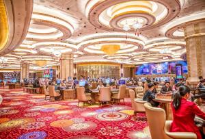 a casino with people sitting at tables in a casino at New World Hoiana Hotel in Hoi An