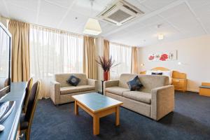 a living room with two couches and a table at Adelaide International Motel in Adelaide