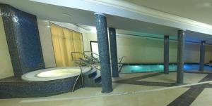 ein großes Badezimmer mit Badewanne und Spiegel in der Unterkunft Hotel Dobosz in Police