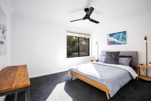 カルバーラ・ビーチにあるGumnut Pet Friendly 5 Mins Walk to Beachのベッドと天井扇風機のある寝室