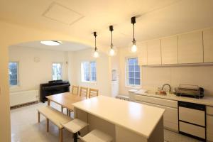 a kitchen with a table and chairs and a counter top at The Garnet Higashikawa in Higashikawa