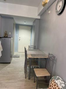 uma cozinha com uma mesa e cadeiras e um frigorífico em Cozy 1 bedroom condo with pool. em Mandaue City