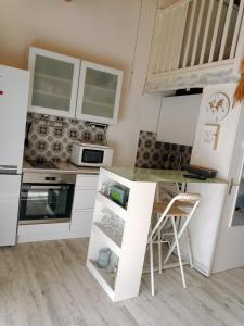 a kitchen with white cabinets and a small table at Mazet de vacances residence l espai in Saint-Martin-de-Brômes