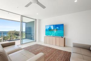 a living room with a couch and a tv at Kings Surf Unit 6 5 Ormonde Tce Kings Beach in Caloundra