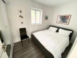博許的住宿－Maison Bellevue - 2 bdrm villa in Borsh beach，卧室配有一张白色大床和一把椅子