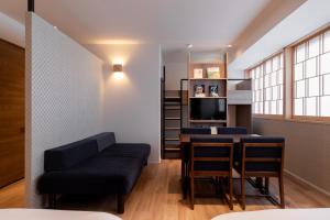 a living room with blue chairs and a table at COCOSHUKU Asakusa Kuramae in Tokyo