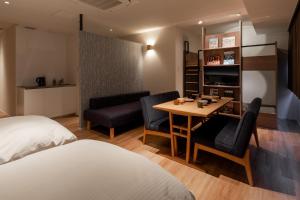 a hotel room with a bed and a table and chairs at COCOSHUKU Asakusa Kuramae in Tokyo
