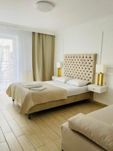 a bedroom with a large bed and a large window at Smart Apartment Ustronie Morskie in Ustronie Morskie