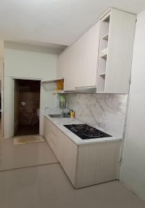 een witte keuken met een fornuis en een wastafel bij EXPRESS O 91293 House in Jember