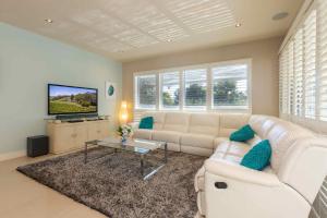 a living room with a white couch and a tv at Stone Grange in Rothbury