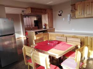 een keuken met een tafel en stoelen en een koelkast bij Departamento REKADI in Cuzco