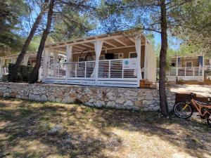 una casa con una pared de piedra y una casa en Premium Mobile Home ZEN SPOT 280, en Jezera