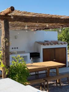 una mesa de picnic de madera en un patio trasero con chimenea en Masía La Costereta, en Catí