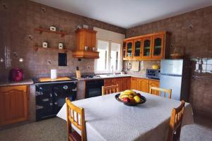 eine Küche mit einem Tisch und einer Obstschale darauf in der Unterkunft Foz Acogedora casa familiar in Barrosa
