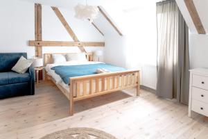 a bedroom with a wooden bed and a couch at Mieszkanie na wsi Mazury Zachodnie in Idzbark
