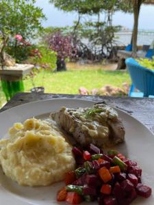 a plate of food with meat and vegetables on a table at Omah Alchy Cottages in Karimunjawa