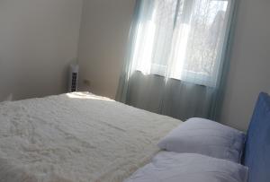 a bedroom with a white bed with a window at Apartman Zrina Oštro in Kraljevica