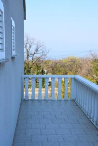 a balcony of a house with a white railing at Apartman Zrina Oštro in Kraljevica