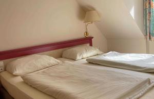 Una cama con dos almohadas encima. en Haus Niedersachsen Apartment 11, en Timmendorfer Strand