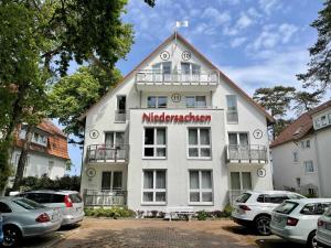 un grande edificio bianco con un cartello sopra di Haus Niedersachsen Apartment 11 a Timmendorfer Strand