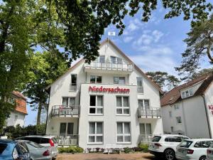 un gran edificio blanco con un cartel. en Haus Niedersachsen Apartment 11, en Timmendorfer Strand