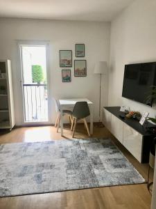 uma sala de estar com uma mesa e uma televisão em Connie's home free parking em Lugano