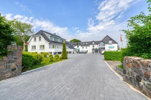 a cobblestone driveway in front of a house at Hotel Seeblick Försterhaus in Owschlag