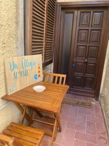 una mesa de madera con un cartel al lado de una puerta en Da Allegro al mare en Talamone