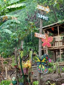 a street sign in a garden with plants at Kambal Kubo Resthouse at Sitio Singalong Bgy San Jose Antipolo in Antipolo