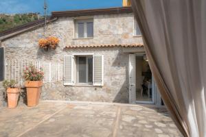 a stone house with a patio in front of it at Casa delle sirene in Letojanni