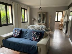 a living room with a blue couch and a table at Appartement spacieux et lumineux Calanques Sormiou in Marseille