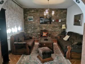 Una sala de estar con muebles de cuero y una pared de ladrillo. en House Leyla, en Bihać