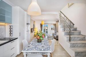 a kitchen and dining room with a table with flowers at Boutique Maisonette in Pefkohori