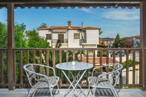 a table and chairs on a balcony with a house at Boutique Maisonette in Pefkohori