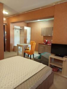 1 dormitorio con cama, mesa y cocina en apartamente si studio joylife, en Costinesti