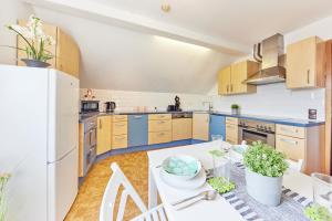 een grote keuken met blauwe kasten en een witte tafel bij Charmant, zentral, nur 5 Gehminuten vom Europa-Park in Rust