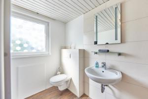 een witte badkamer met een wastafel en een toilet bij Charmant, zentral, nur 5 Gehminuten vom Europa-Park in Rust